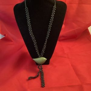 Long black beaded necklace with a bead shaped like a bird